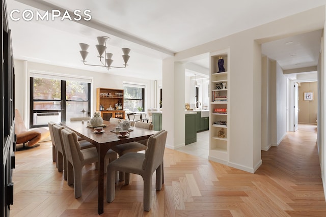 dining space featuring a notable chandelier and baseboards