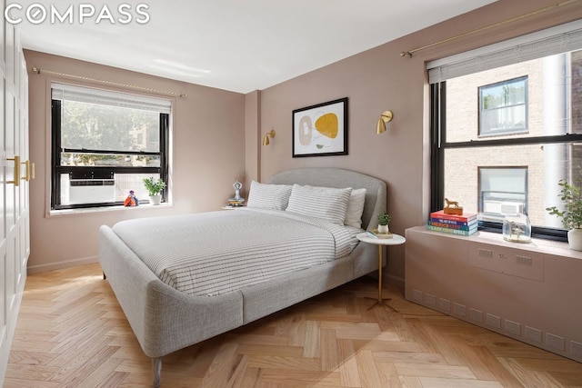 bedroom with multiple windows and light parquet flooring