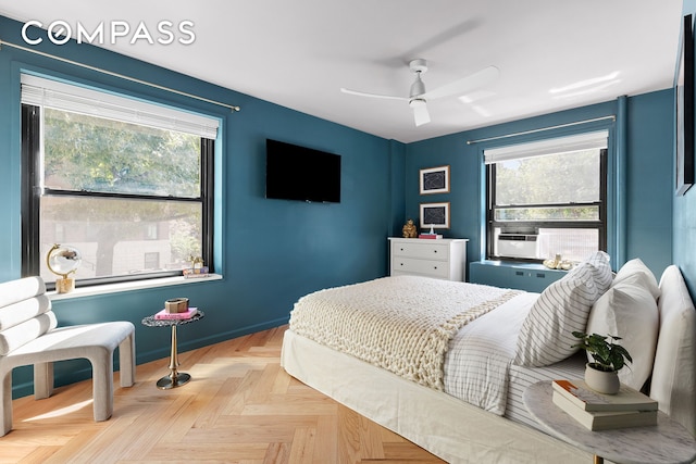 bedroom featuring ceiling fan, multiple windows, and baseboards