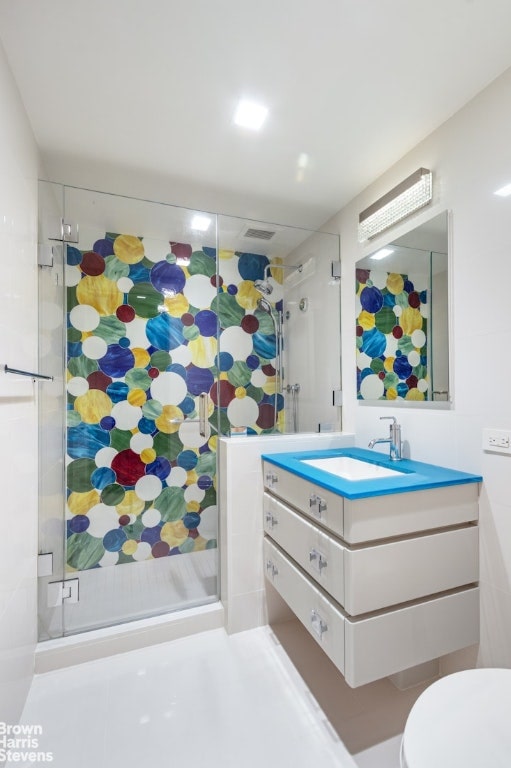 bathroom with vanity, toilet, and an enclosed shower