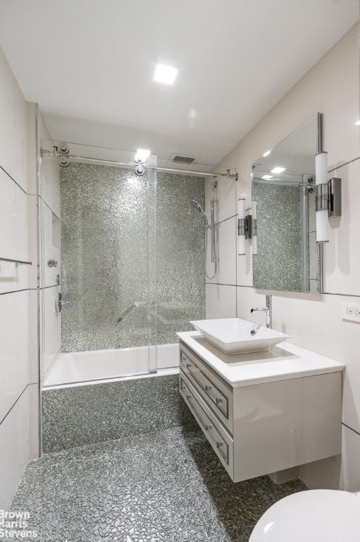 full bathroom with vanity, toilet, and tiled shower / bath