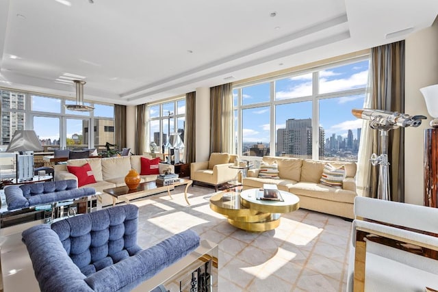 tiled living room featuring a raised ceiling and floor to ceiling windows