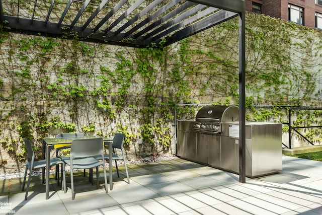 wooden terrace with outdoor dining space, a pergola, a grill, exterior kitchen, and a patio area