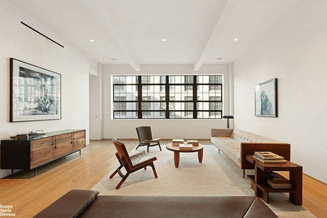 living room with recessed lighting, plenty of natural light, beam ceiling, and light wood-style floors