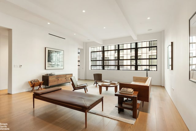 living area with light wood-style flooring, beam ceiling, and recessed lighting