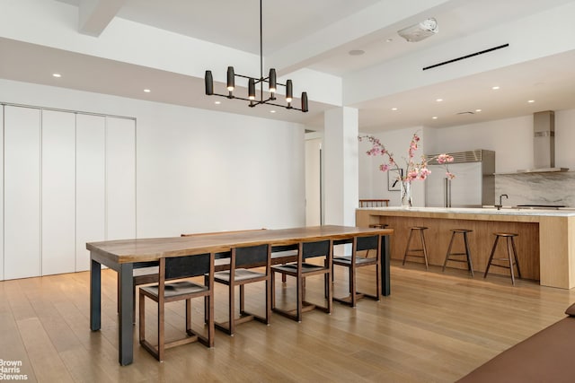 dining area featuring beam ceiling, recessed lighting, and light wood finished floors