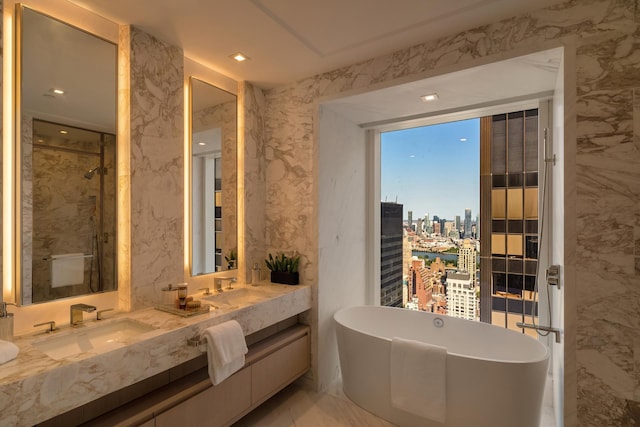 bathroom featuring a freestanding tub, marble finish floor, a city view, a sink, and double vanity