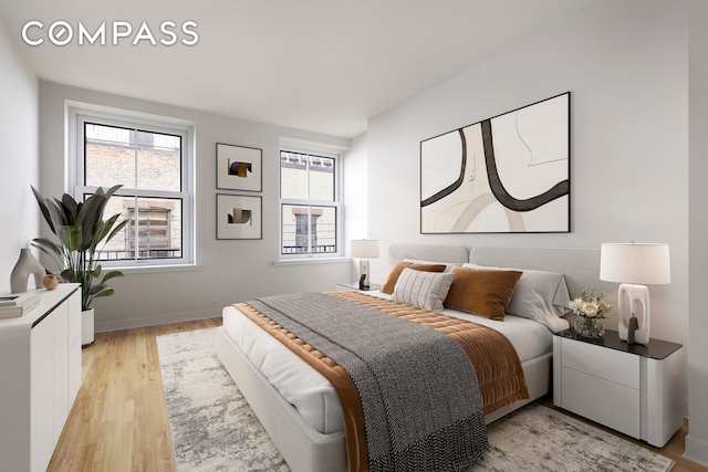 bedroom featuring light wood finished floors and baseboards