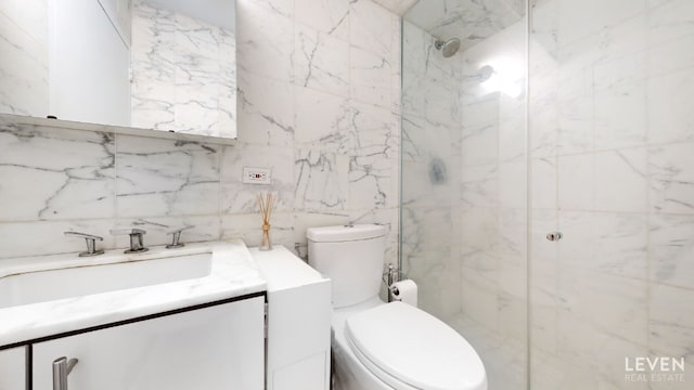 full bathroom with toilet, a marble finish shower, tile walls, and vanity