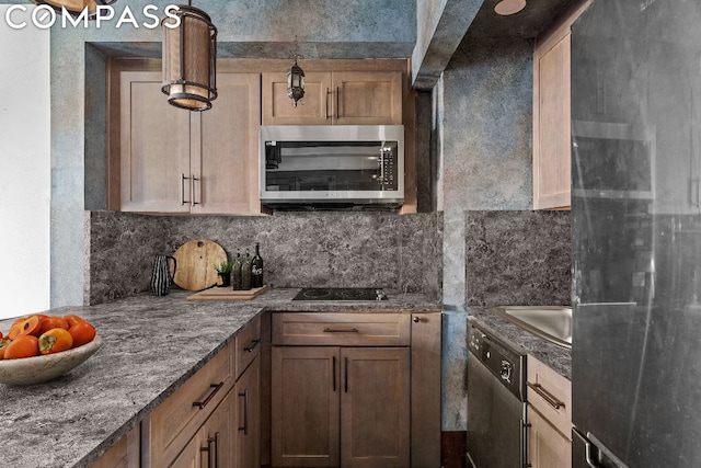 kitchen with stainless steel appliances, hanging light fixtures, dark stone countertops, and decorative backsplash