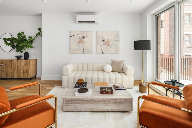 living area with recessed lighting, a wall mounted air conditioner, wood finished floors, and baseboards