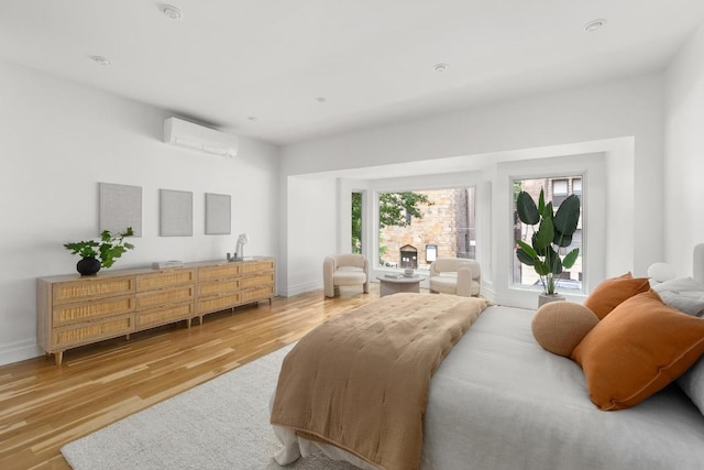 bedroom with hardwood / wood-style flooring and a wall mounted air conditioner