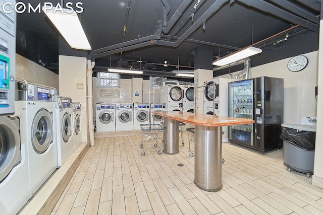 laundry room with stacked washer and clothes dryer, washer and clothes dryer, and wood-type flooring