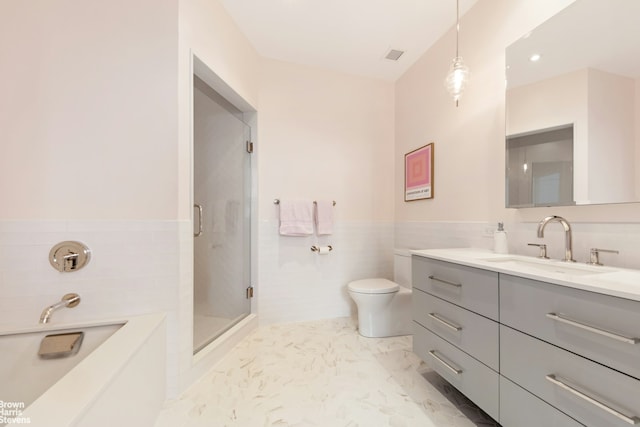 full bath with vanity, a stall shower, tile walls, toilet, and marble finish floor