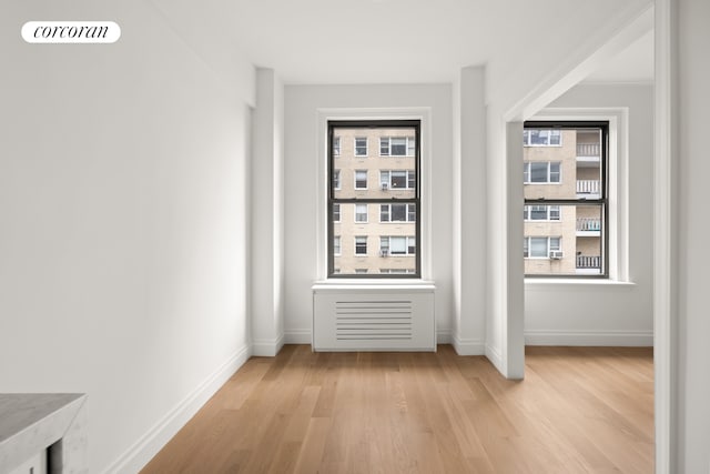 hallway with visible vents, light wood-type flooring, and baseboards