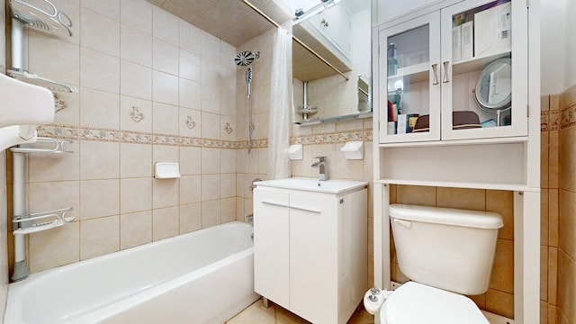 full bathroom featuring tile walls, backsplash, vanity, shower / tub combo, and toilet