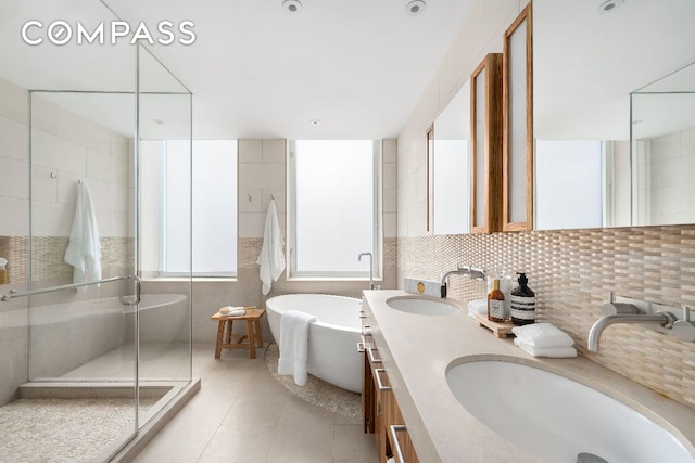 bathroom with tile patterned flooring, vanity, decorative backsplash, and shower with separate bathtub