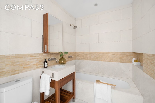 full bathroom featuring toilet, sink, tasteful backsplash, tile walls, and tiled shower / bath combo