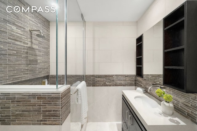 bathroom featuring tile walls, vanity, and tiled shower