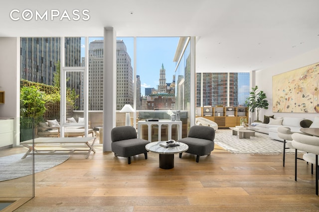 living area with expansive windows, a city view, and hardwood / wood-style flooring