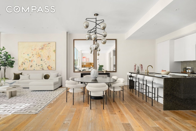 dining room featuring light wood-type flooring and an inviting chandelier