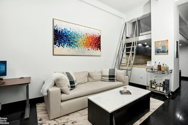 living area with baseboards and wood finished floors