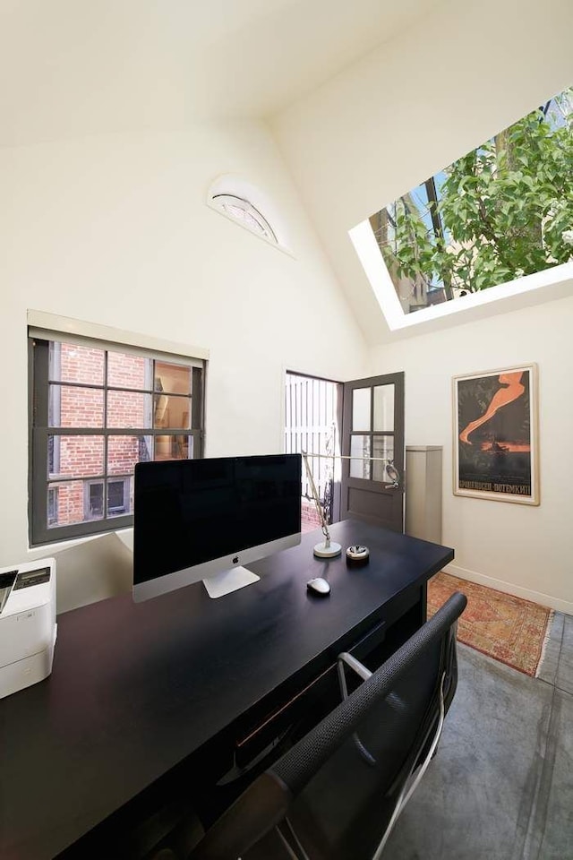 office area featuring high vaulted ceiling and a skylight