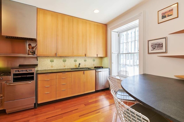 kitchen featuring dark countertops, dishwasher, a sink, and open shelves