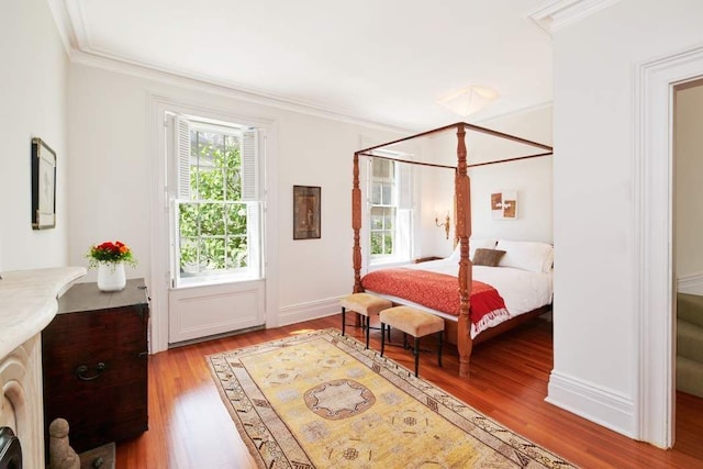 bedroom with baseboards, wood finished floors, and crown molding