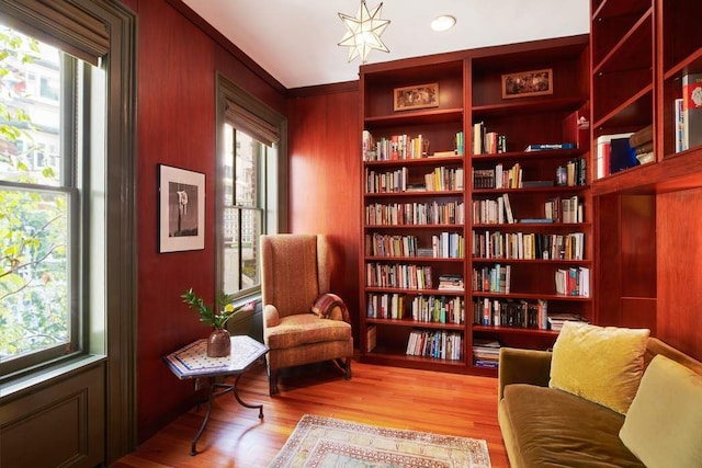 living area featuring built in features, a wealth of natural light, and wood finished floors