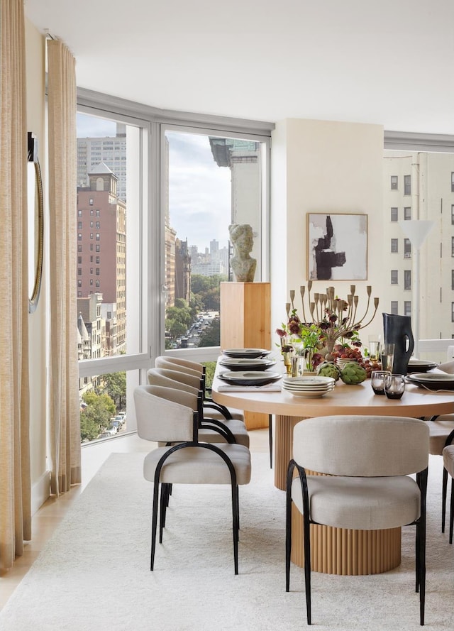 dining space with a wall of windows, a city view, and plenty of natural light