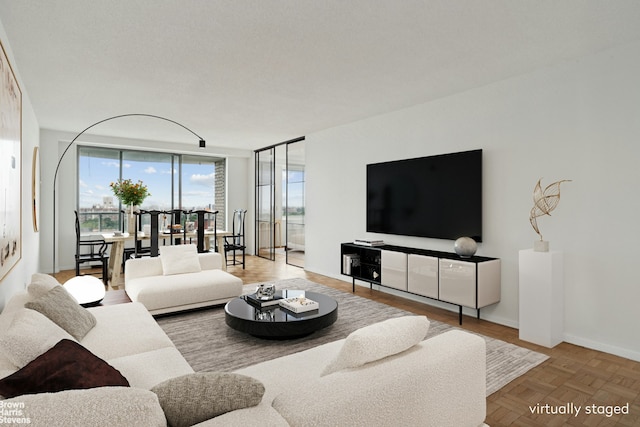 living area featuring floor to ceiling windows and baseboards