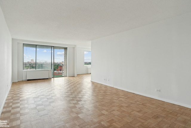 unfurnished room featuring baseboards and a textured ceiling