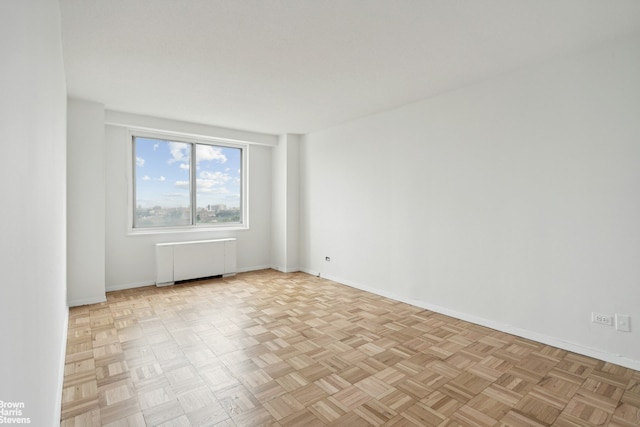 spare room with baseboards and radiator heating unit