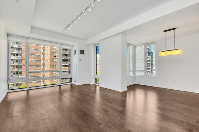 unfurnished room with dark wood-type flooring and track lighting