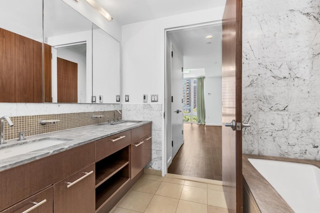 bathroom featuring tile walls, tile patterned floors, vanity, and a bathing tub