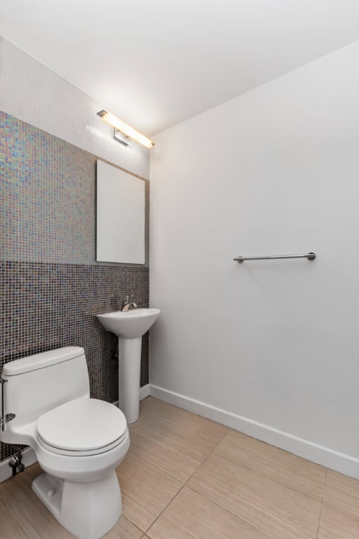 bathroom with sink, toilet, and tile patterned flooring