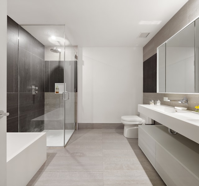 full bath with double vanity, visible vents, decorative backsplash, toilet, and a shower stall