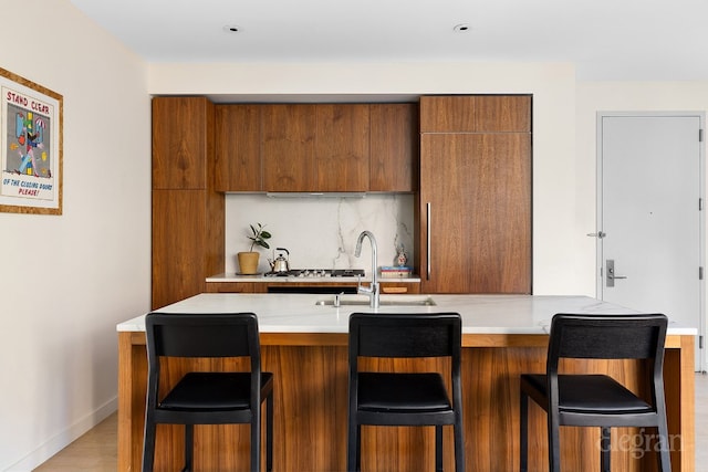 kitchen with modern cabinets, a breakfast bar area, and light countertops