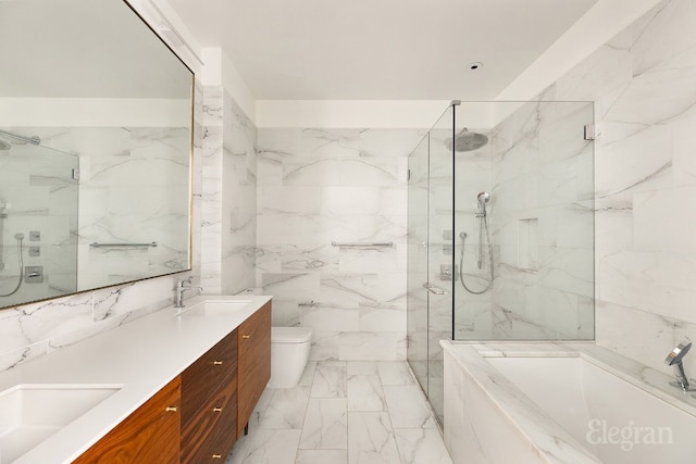 bathroom with marble finish floor, a garden tub, a sink, and stone wall