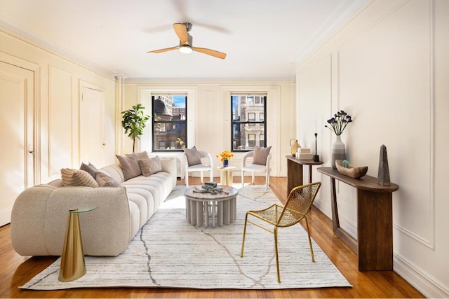 living room featuring ceiling fan, crown molding, and light hardwood / wood-style floors