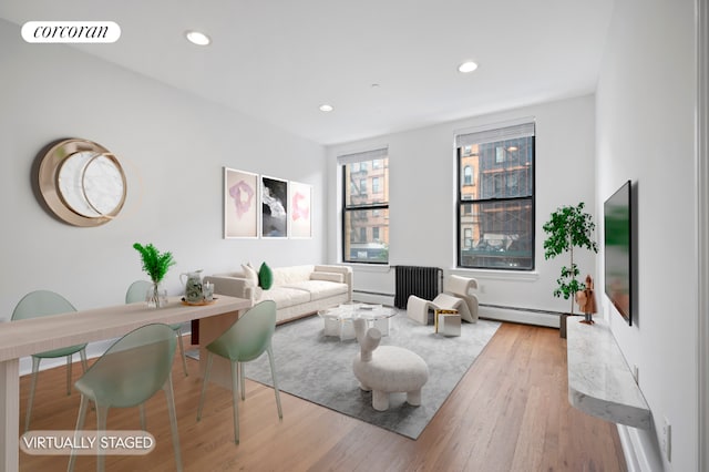 living room featuring light hardwood / wood-style floors and a baseboard heating unit