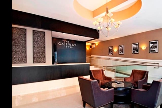 welcome area featuring a chandelier and a wainscoted wall