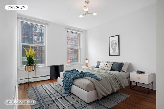 bedroom featuring baseboard heating, wood finished floors, visible vents, and radiator