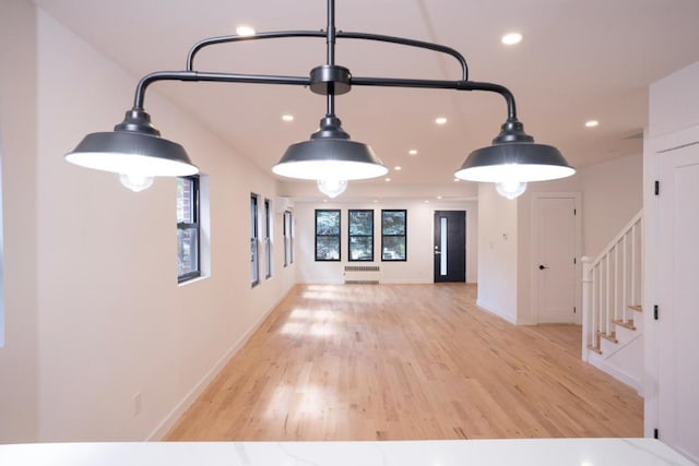 interior space featuring radiator heating unit and light hardwood / wood-style floors