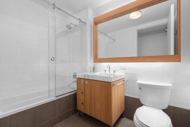 full bathroom featuring toilet, vanity, tiled shower / bath, and tile patterned flooring