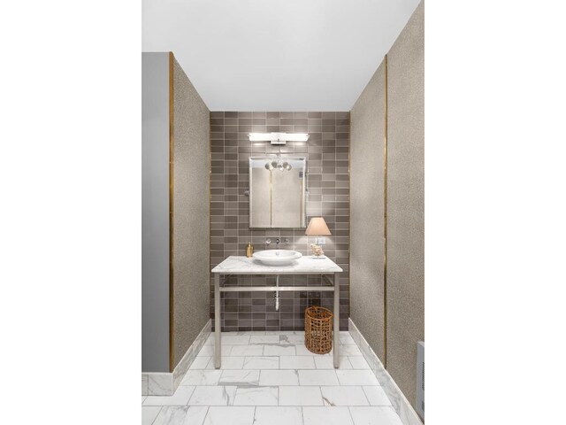 bathroom with sink and tile walls