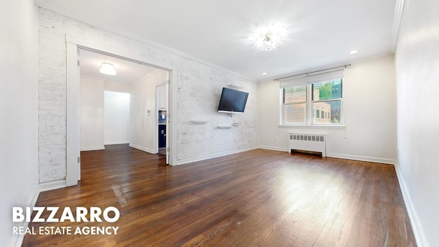 unfurnished living room featuring ornamental molding, brick wall, dark hardwood / wood-style floors, and radiator heating unit