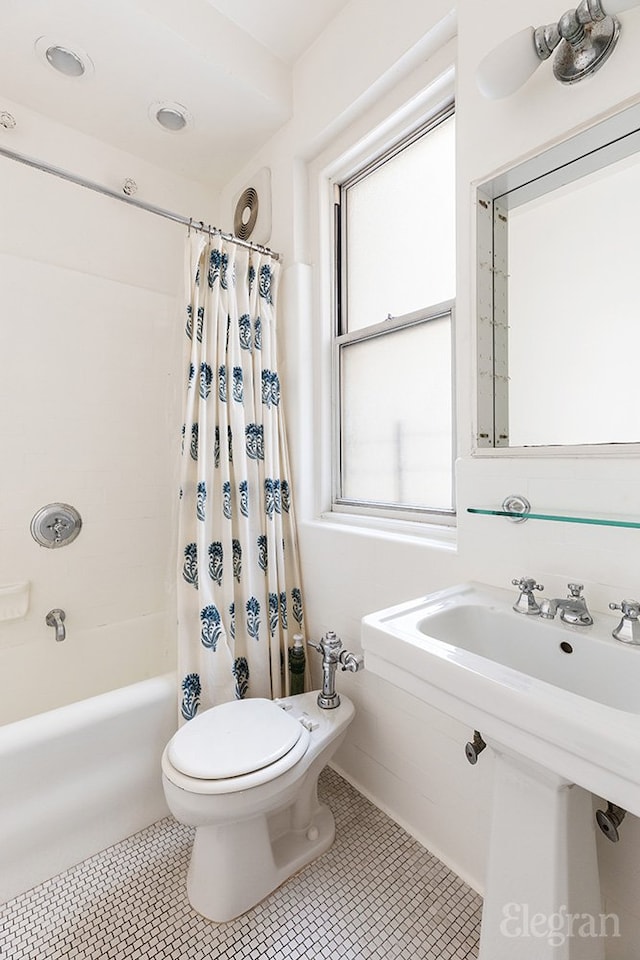 bathroom with shower / bath combination with curtain, tile patterned flooring, and toilet