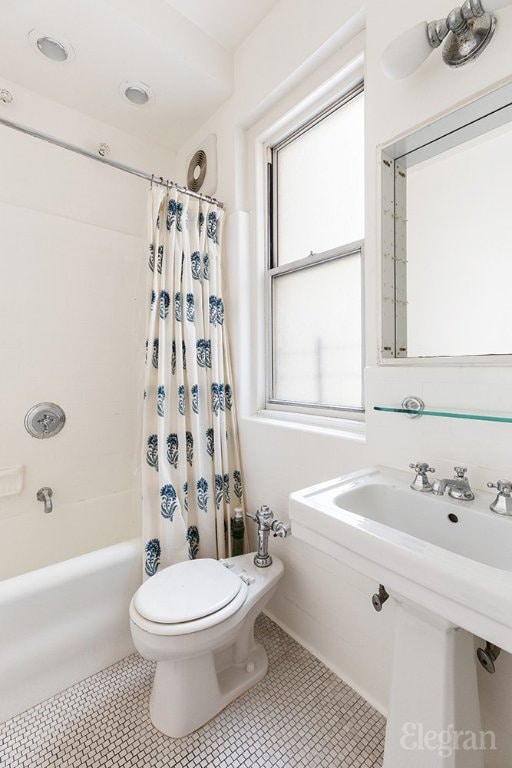 bathroom with shower / tub combo with curtain, tile patterned floors, and toilet